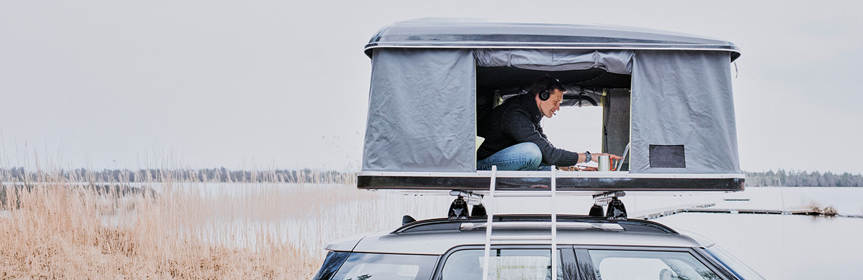Mężczyzna w średnim wieku siedzi przy stoliku na zewnątrz, gdzieś w podróży podczas przerwy i prowadzi wideorozmowę z ekspertem hipotecznym z ING.