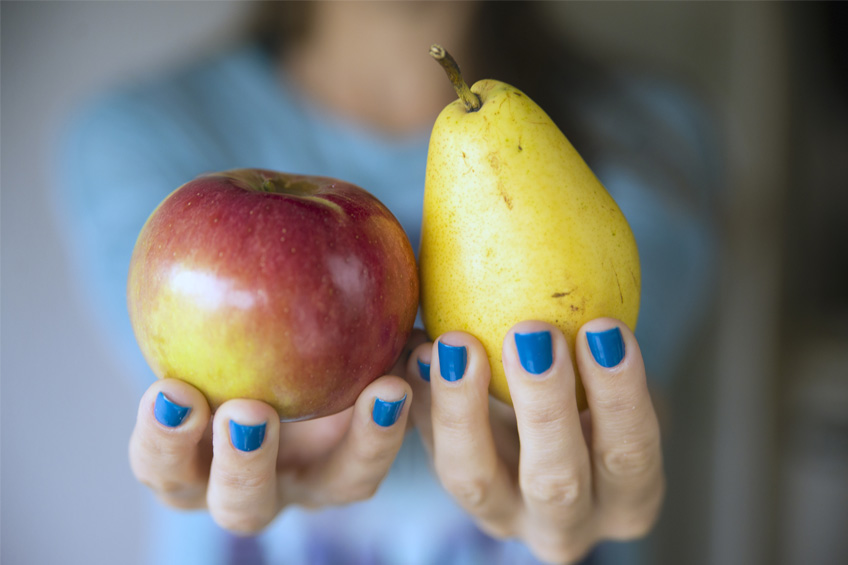 Jabłko i gruszka trzymane w dłoni
