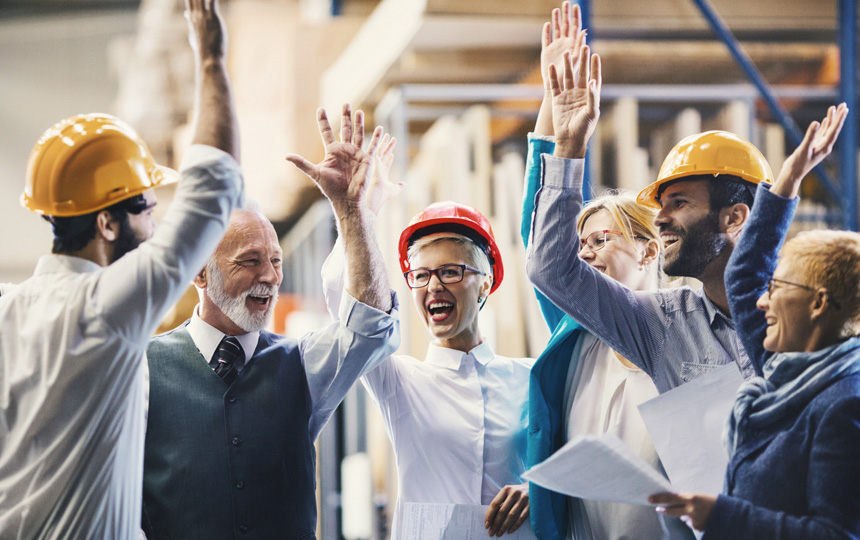 Grupa ludzi w średnim wieku radośnie przybija sobie piątki