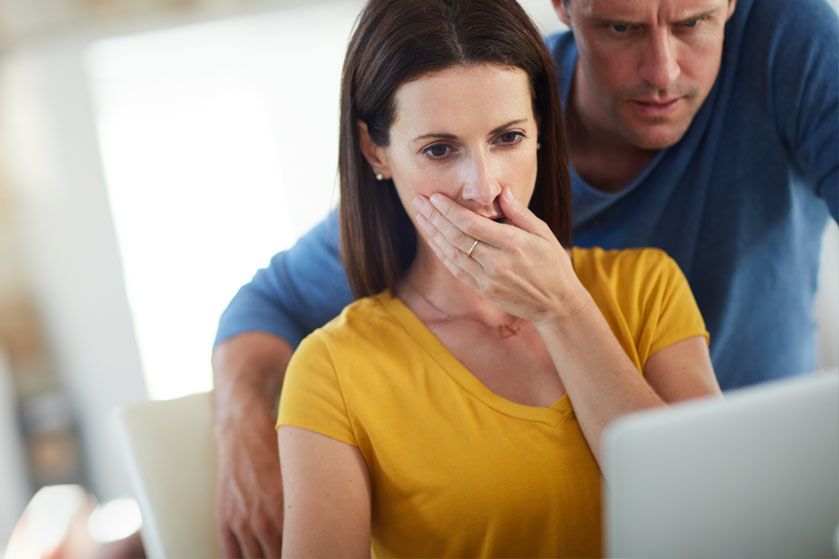 Małżeństwo ze zmartwionymi minami przygląda się ekranowi komputera
