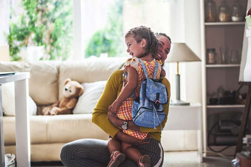 Mama przytula córkę gotową na rozpoczęcie roku szkolnego