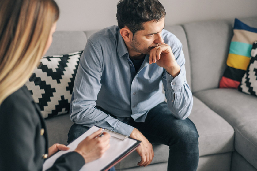 Zmartwiony mężczyzna siedzi na kanapie