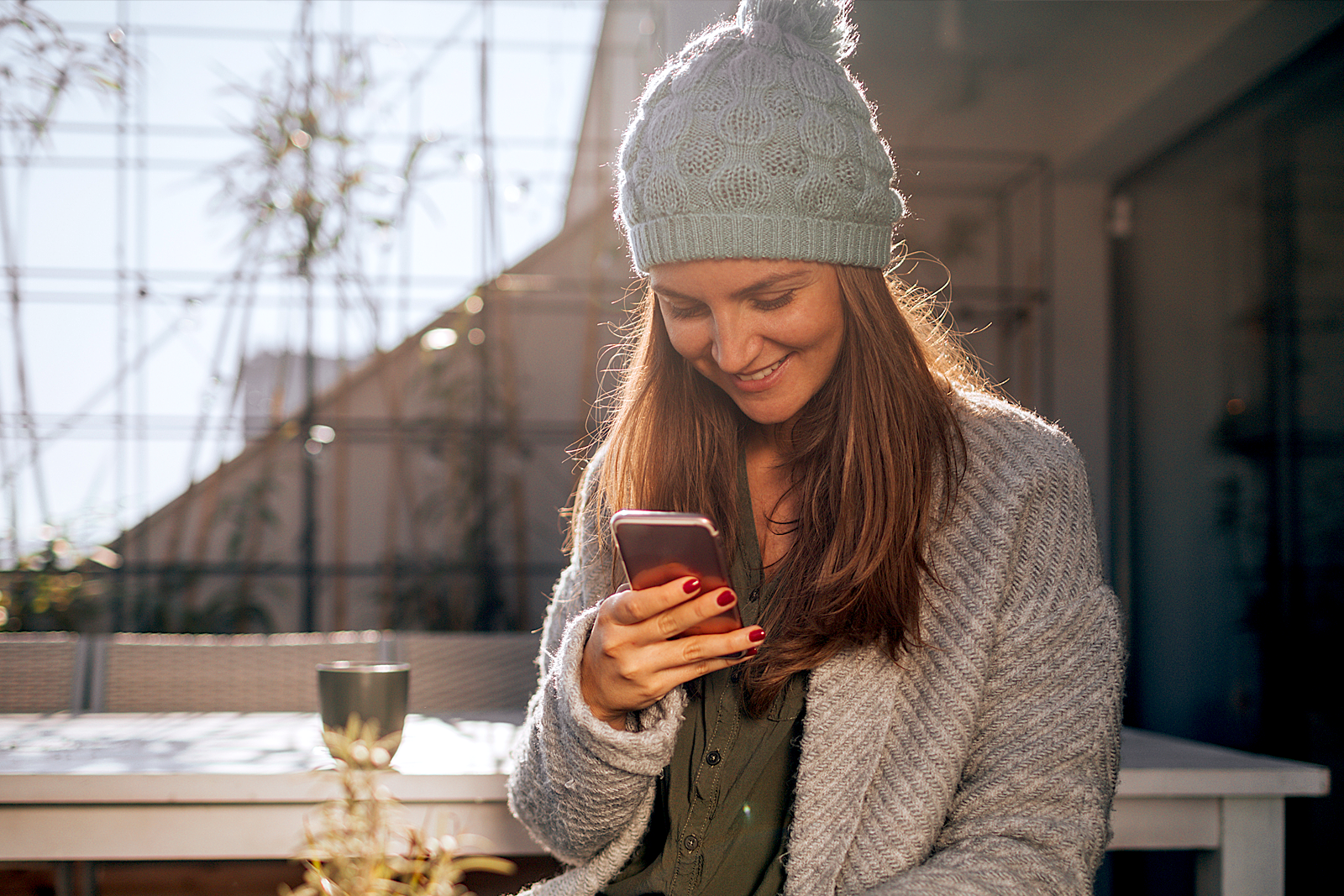 Uśmiechnięta kobieta korzysta ze swojego smartfona