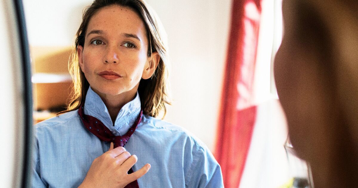 Kobieta w koszuli wiąże sobie krawat