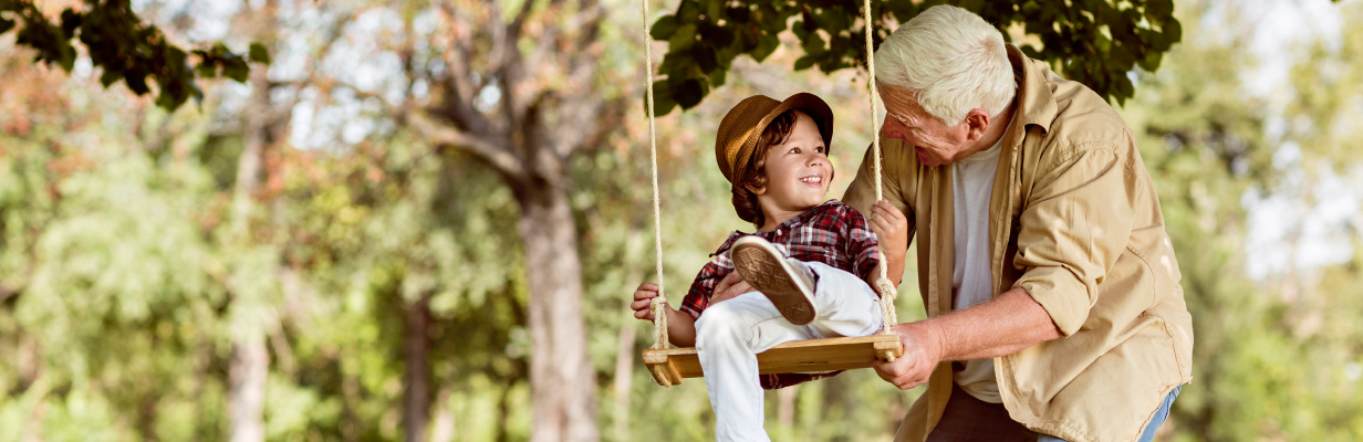 Dziadek spędza czas z wnuczkiem na hustawce