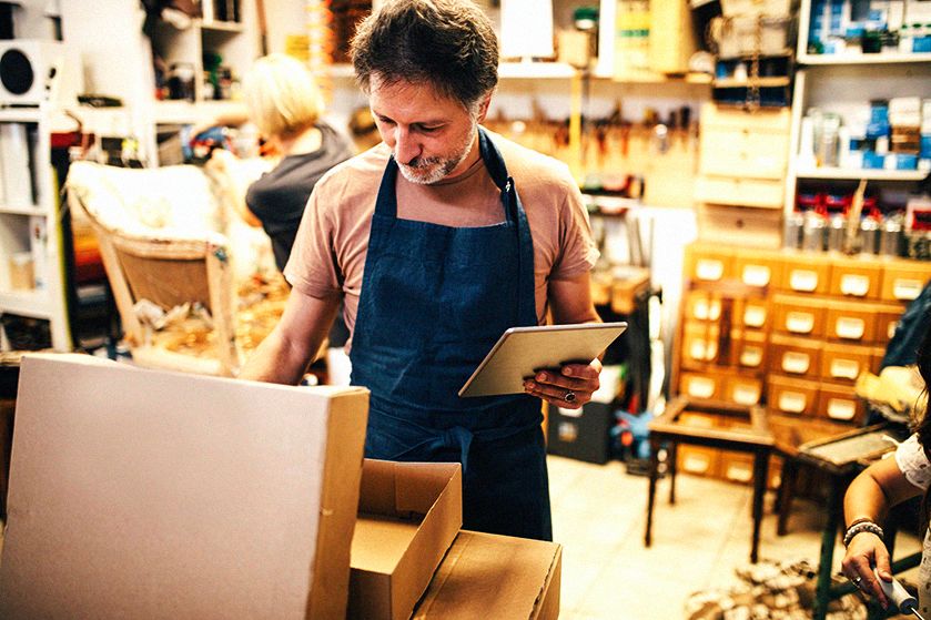 Mężczyzna z tabletem w dłoni w warsztacie tapicerskim
