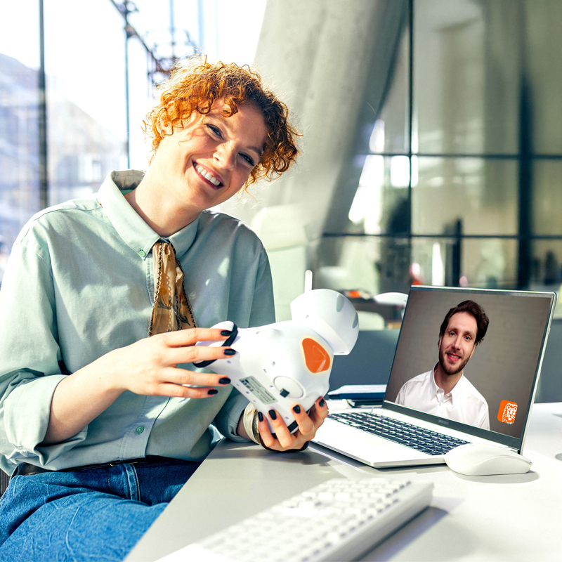 Młoda przedsiębiorczyni rozmawia z księgowym na wideo pokazując swojego robota