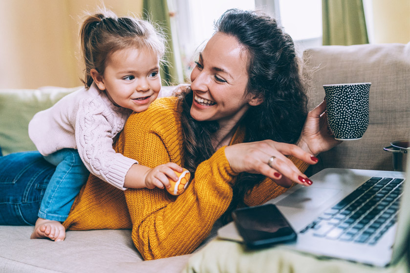 Uśmiechnięte mama z córką przed komputerem