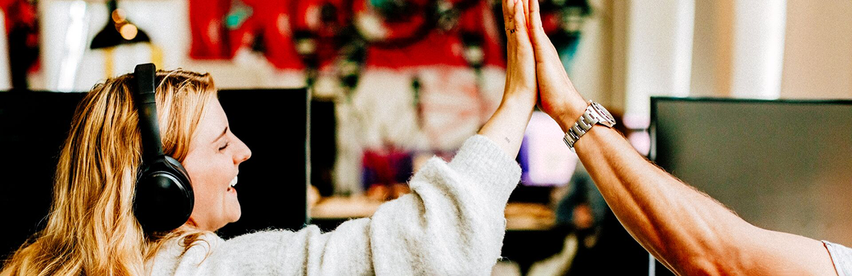 Kobieta i mężczyzna przybijają sobie piątkę w biurze