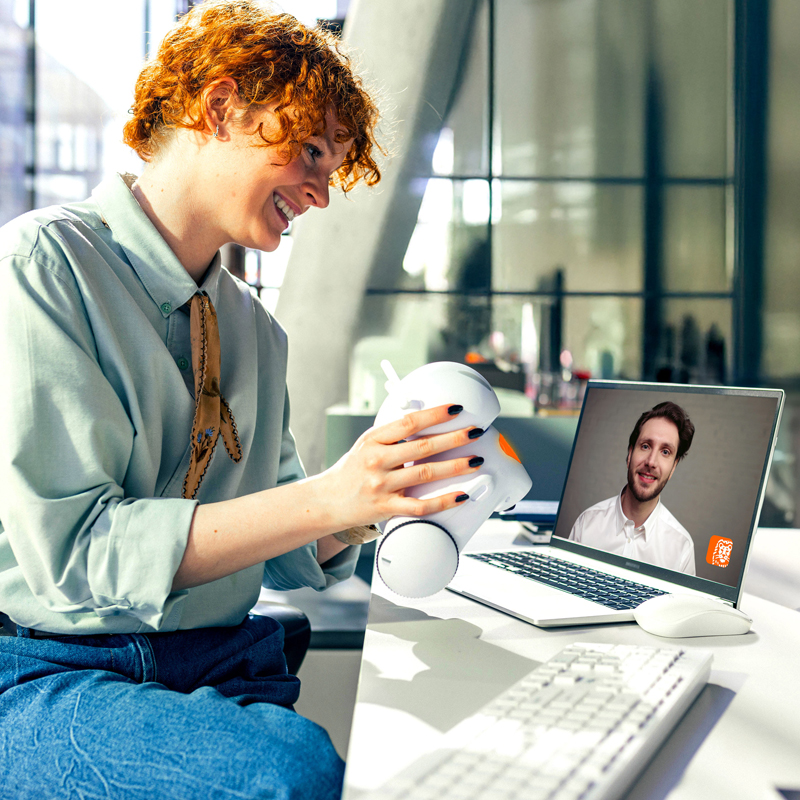 Młoda przedsiębiorczyni rozmawia z księgowym na wideo pokazując swojego robota
