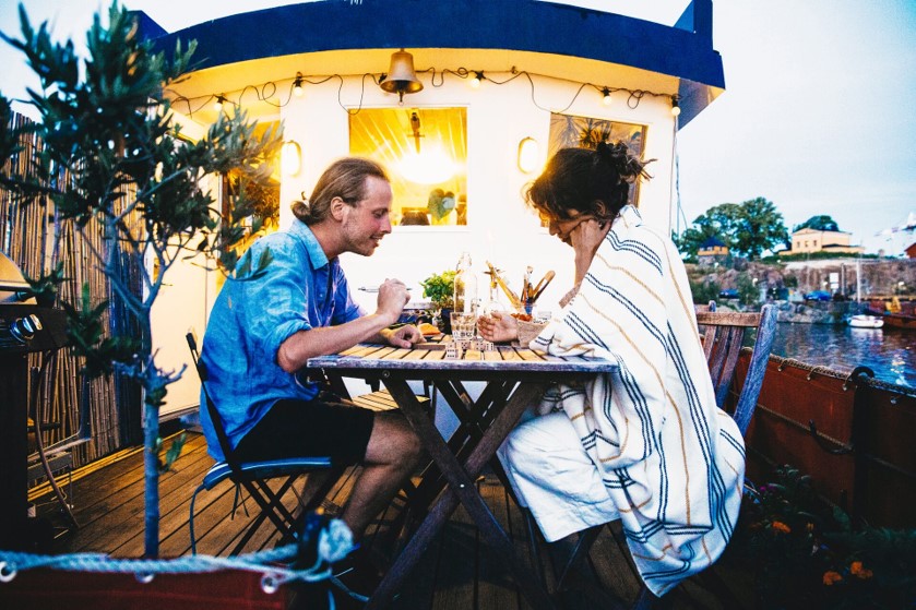 Para jest w restauracji, siedzą przy stoliku na zewnątrz i jedzą posiłek