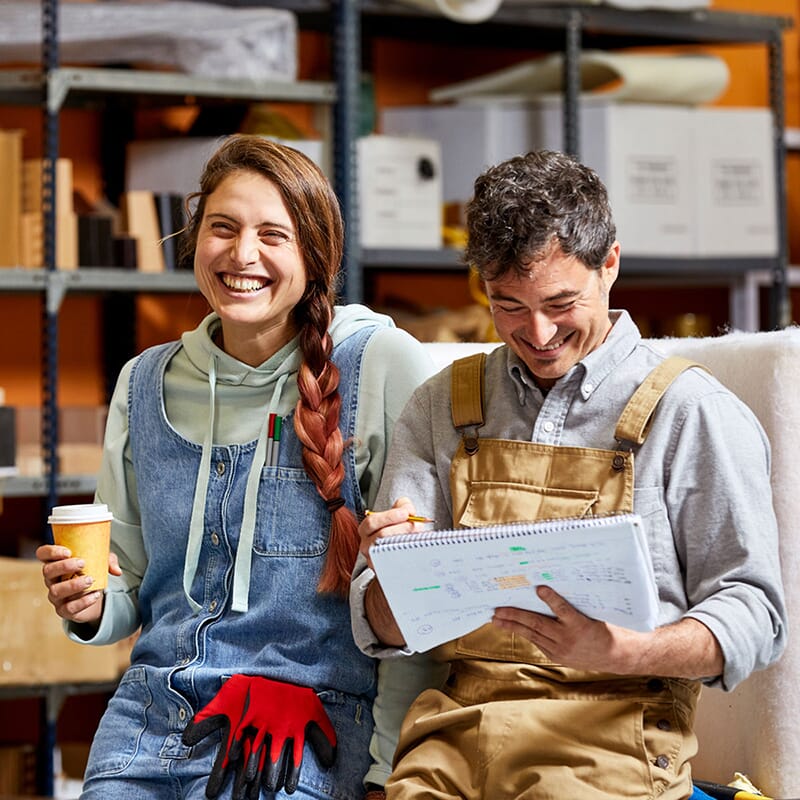 Dwoje uśmiechniętych przedsiębiorców w magazynie