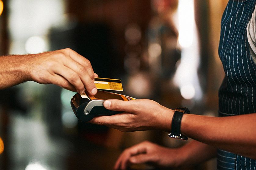 Płatność kartą na terminalu płatniczym - dłoń z kartą i dłoń z terminalem