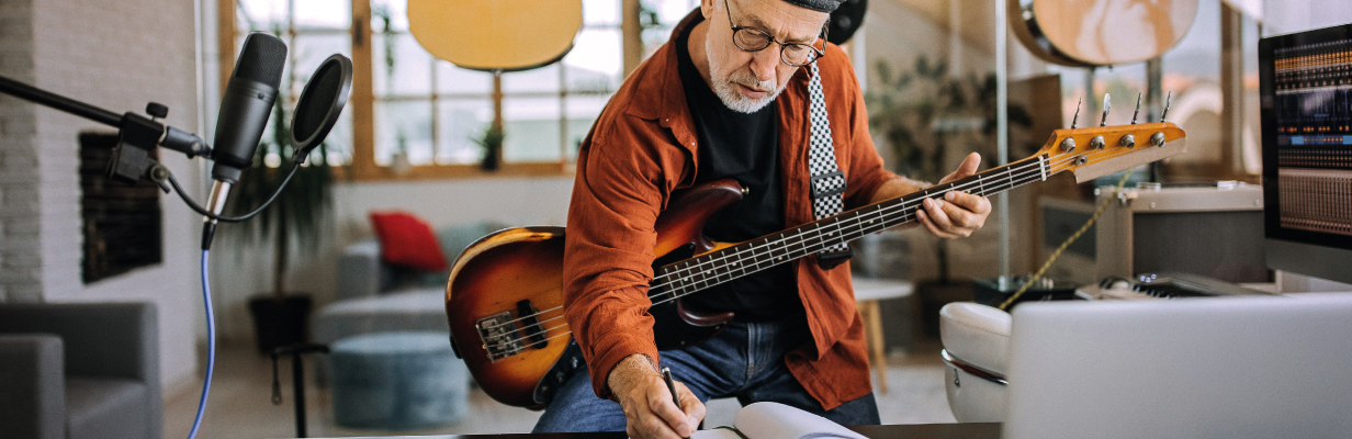 Starszy mężczyzna uczy się grać na gitarze