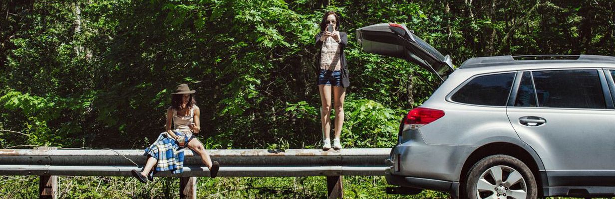 Dwie młode kobiety robią postój podczas podróży samochodem