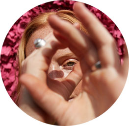 Dziewczyna udaje, że z dłoni robi lornetkę i patrzy przez nią.