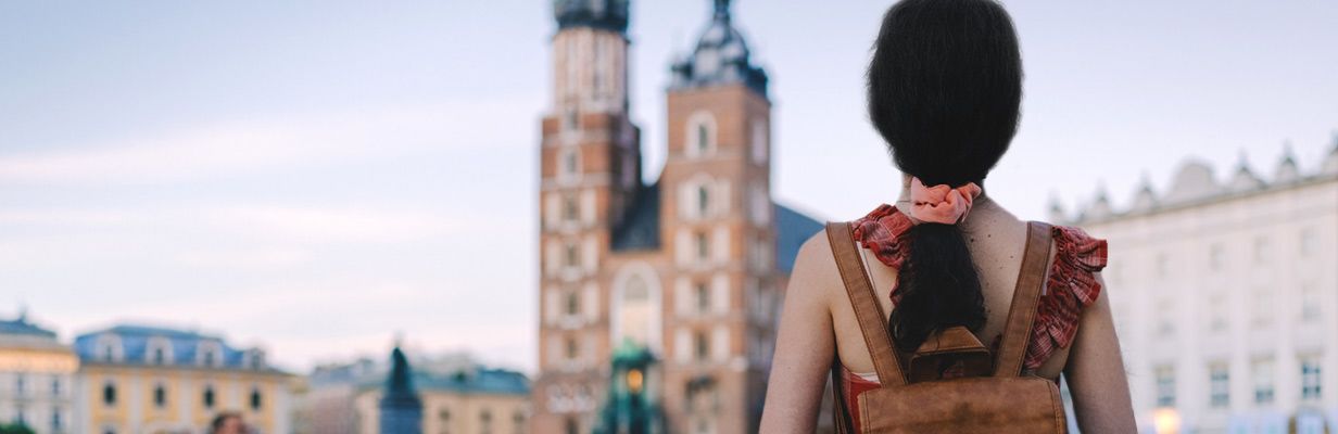 Dziewczyna stoi na rynku w Krakowie i przygląda się zabytkom